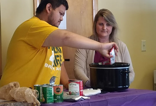 A man and women make chili for a Healthfirst community event