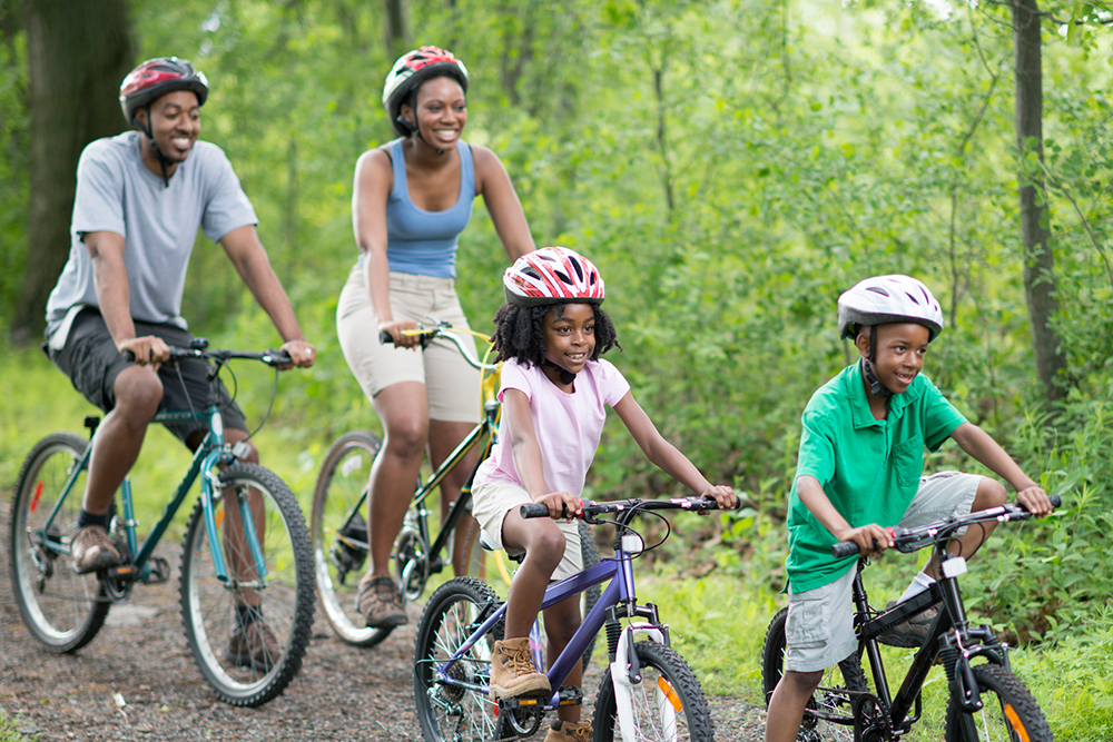 Mom, dad, young boy and girl on a bike ride